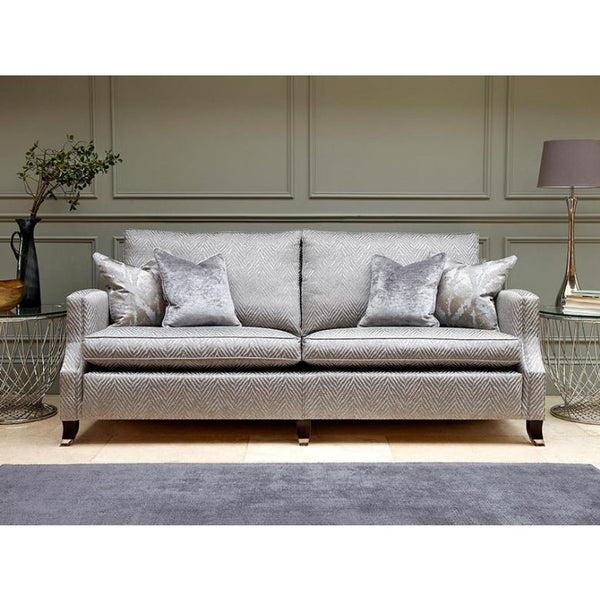 Grey patterned sofa with decorative pillows in a room setting.