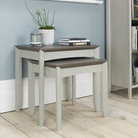 Set of two nesting tables with a wooden top and grey base in a room setting.
