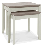 Set of two nesting tables with a light grey base and brown top on a white background