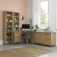 Home office with wooden furniture, including a bookshelf, desk, and sideboard.