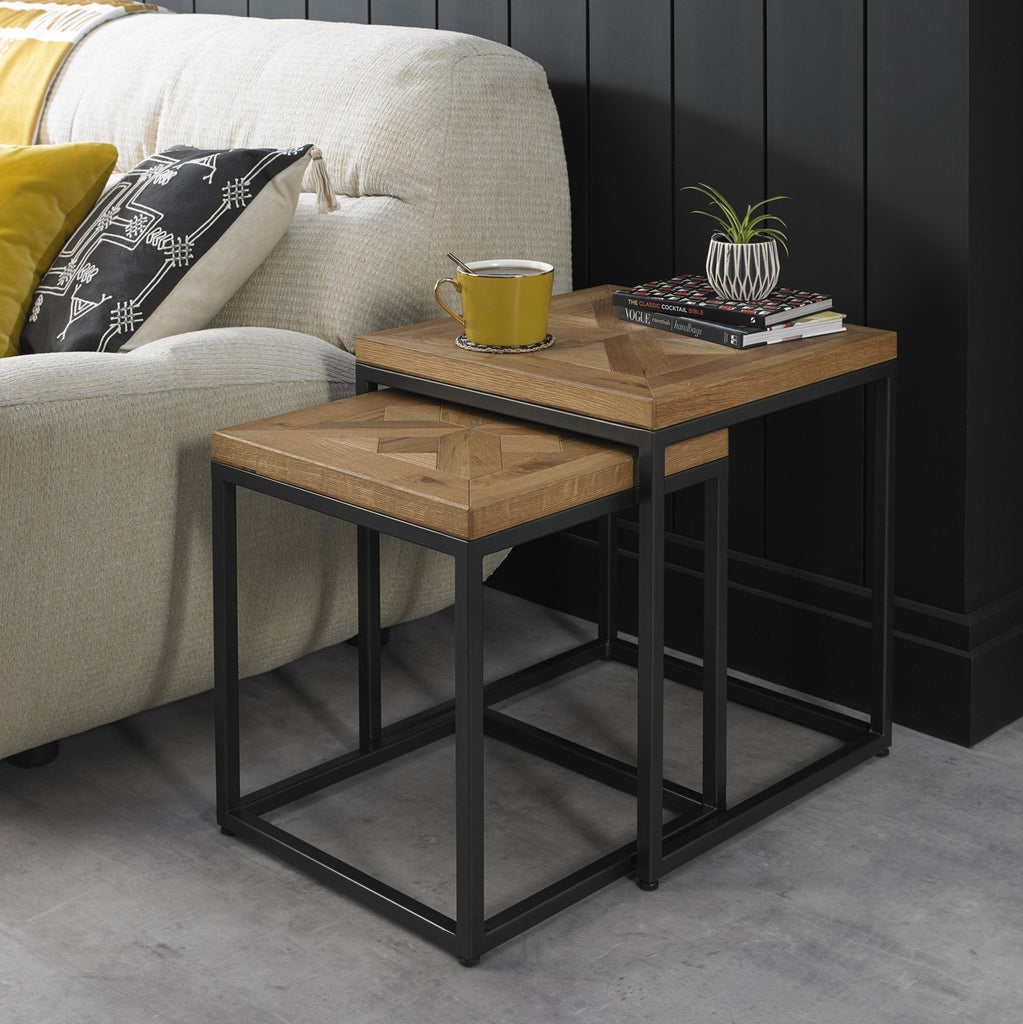 Wooden side table with a yellow mug and books next to a beige sofa.