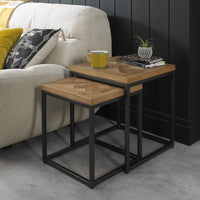 Wooden side table with a yellow mug and books next to a beige sofa.