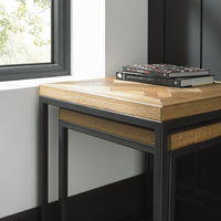 Wooden side table with black metal legs against a neutral wall.