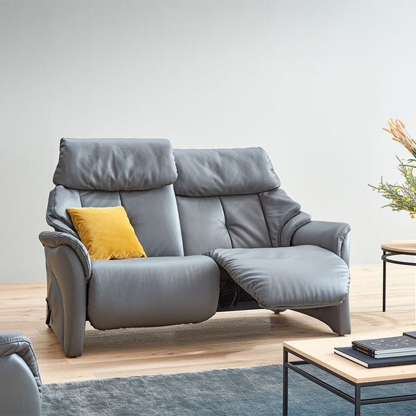 Grey leather sofa with a yellow pillow in a modern living room setting.