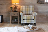 Plaid armchair in a room with wooden walls and a side table.