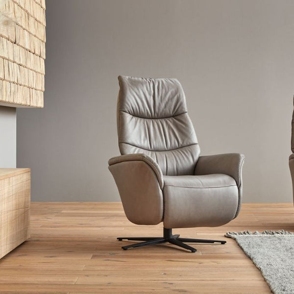 Grey leather recliner chairs in a modern living room setting with wooden floor and neutral walls.