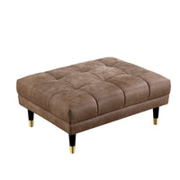 A square tufted ottoman in brown leather, featuring black legs with gold-colored metallic tips, shown on a plain white background.