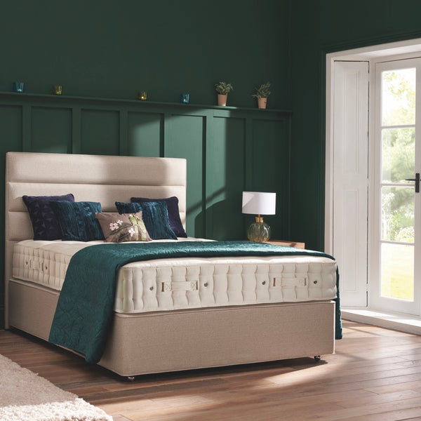 Bedroom with a bed, nightstands, and a desk against a green wall.