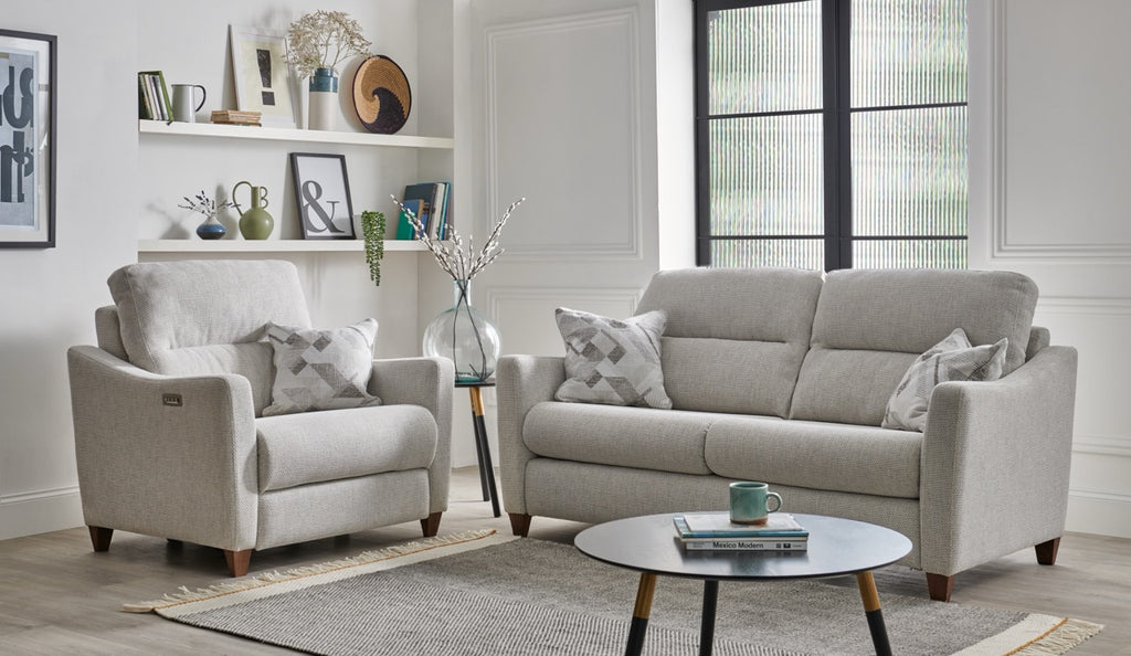 Grey sofa set in a living room with a coffee table and decorative items.