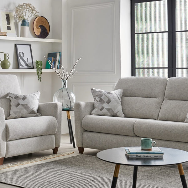 Grey sofa set in a living room with a coffee table and decorative items.