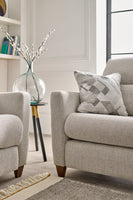 Grey sofa with a patterned pillow in a living room setting.