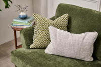 Green sofa with patterned cushions in a room setting