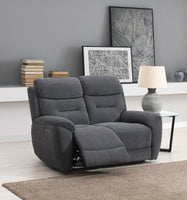 Grey recliner sofa in a living room setting with books and framed pictures on a shelf.