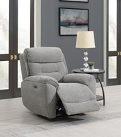 Grey recliner chair in a living room setting with a lamp and table.