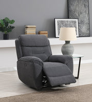 Grey recliner chair in a living room setting with a lamp, books, and plant.