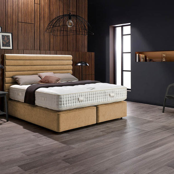 Bedroom with a beige bed and wooden flooring