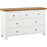 White dresser with six drawers and a wooden top on a white background