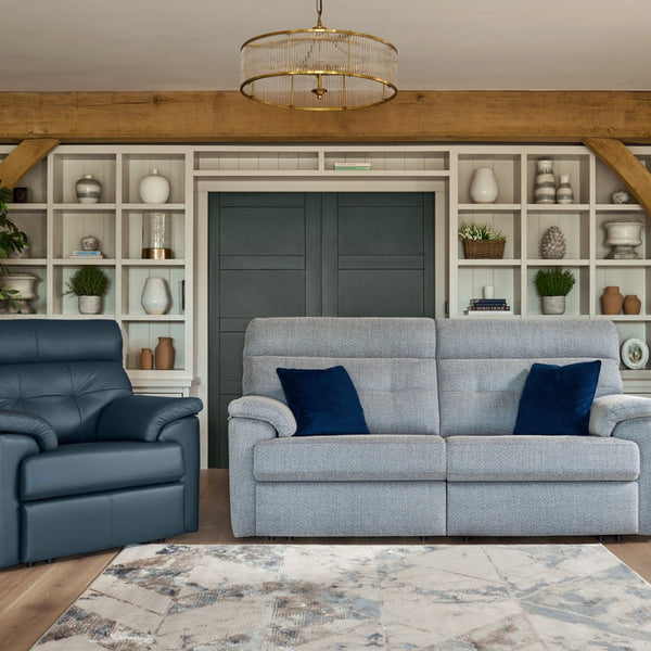 Living room with grey sofa, blue armchair, and decorative elements.