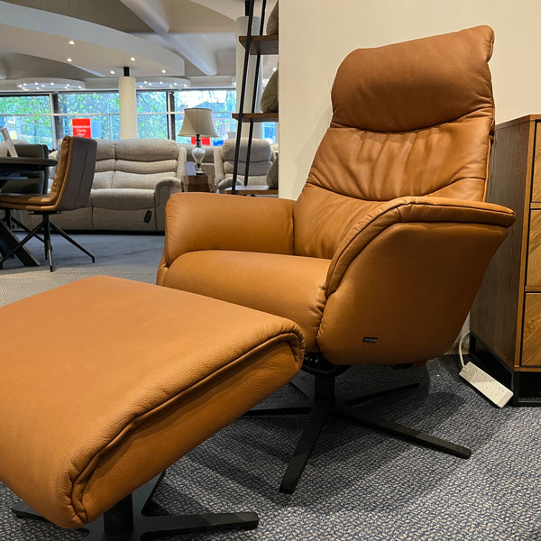 Brown leather recliner chair with stool in a showroom setting