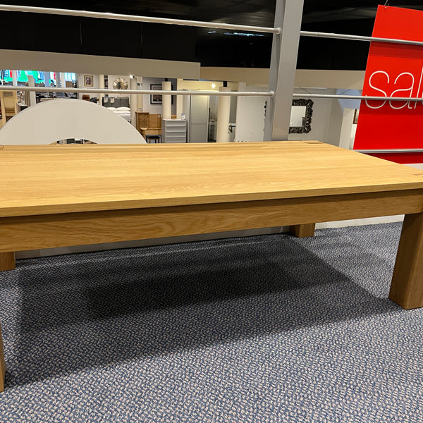 Wooden table in a store with a 'sale' sign in the background