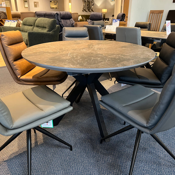 Round dining table with chairs in a furniture store setting