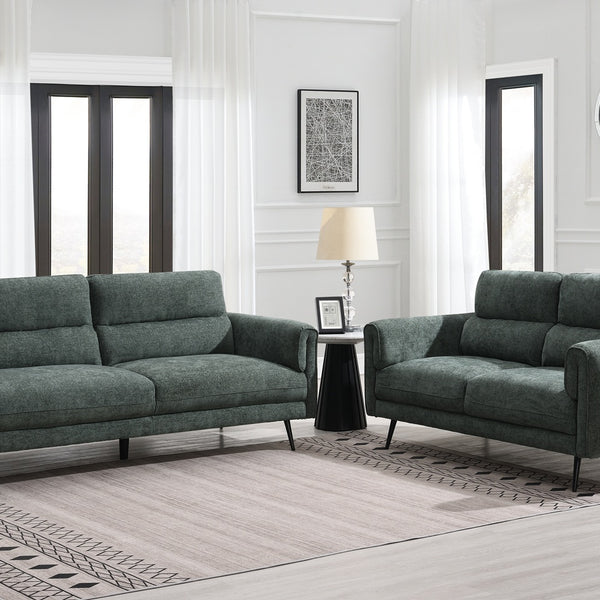 Green sofa set in a living room with white walls and wooden floor.