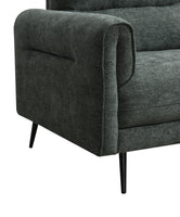 Green upholstered sofa with black metal legs on a white background