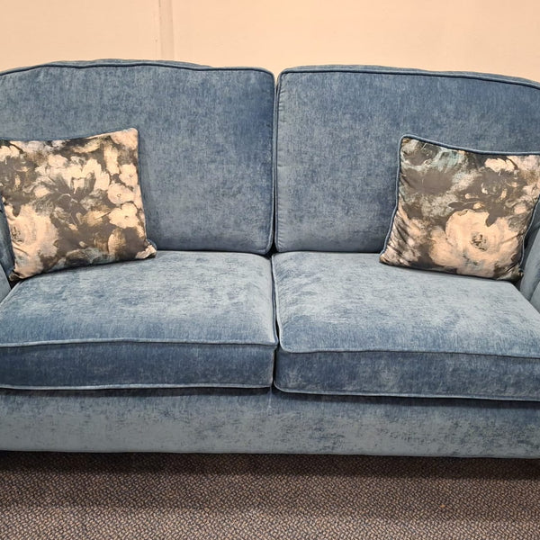Blue sofa with floral-patterned cushions in a room setting