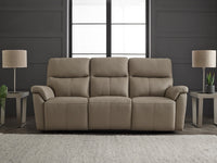 Beige sofa in a living room setting with lamps and windows.