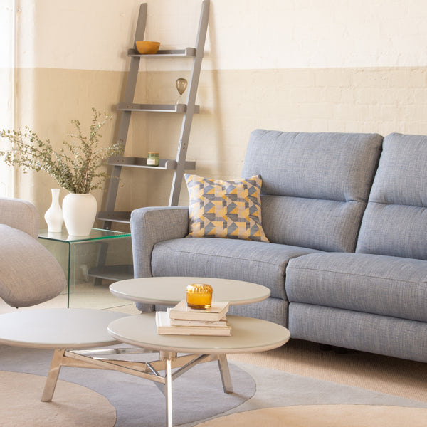 Modern living room with a blue sofa, armchair, and coffee table.