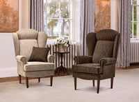 Two upholstered armchairs in a room with curtains and a window.