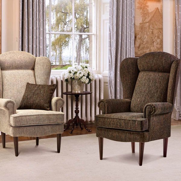 Two upholstered armchairs in a room with curtains and a window.