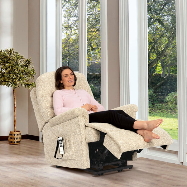 Woman relaxing in a beige recliner chair in a bright room with large windows.