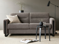Grey sofa in a living room with a side table and decor items.