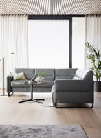 Modern living room with a grey sectional sofa, coffee table, and decorative elements.