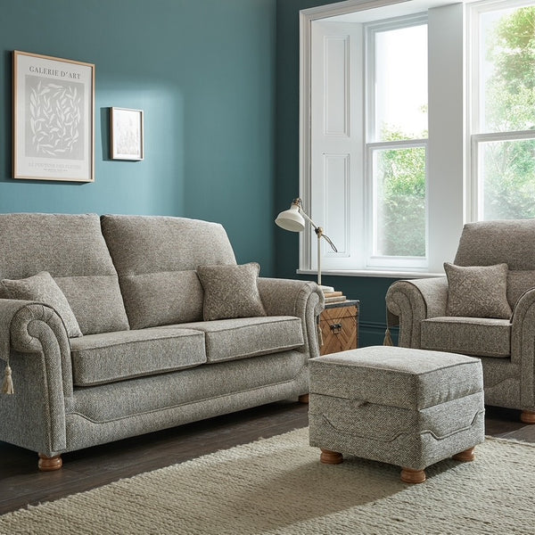 Grey sofa set in a living room with teal walls and large windows.