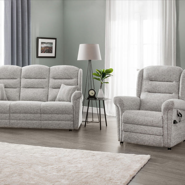 Grey sofa and armchair set in a living room with a lamp and plant.