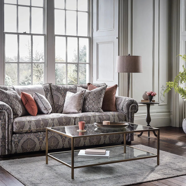 Living room with a patterned sofa, coffee table, and decorative items.