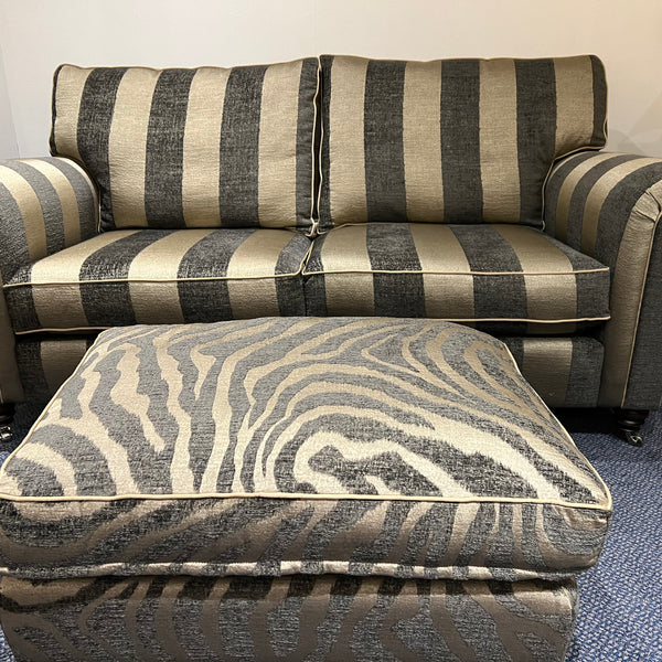 Gold and grey striped sofa and tiger patterned footstool