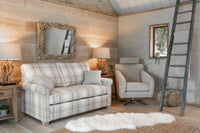 Cozy living room with plaid sofa, armchair, and decorative elements.
