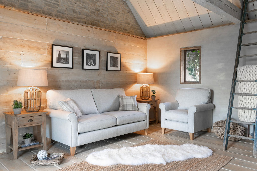 Cozy living room with grey sofa, armchair, and wooden furniture.