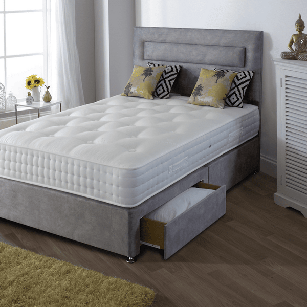 Bedroom with a bed featuring a white mattress and grey headboard, next to a white cabinet.