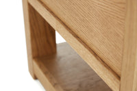 Close-up of a wooden side table with a light finish.
