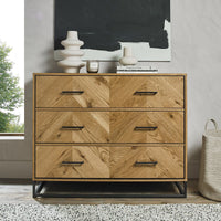 Wooden dresser with four drawers in a room setting with decor items on top.