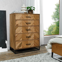 Wooden dresser with chevron pattern in a room with a window and bed.