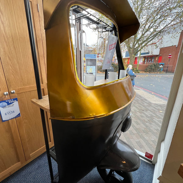 Half a tuc tuc with a bar behind it