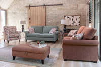 Living room with brown and grey sofas, footstool, and decorative pillows.
